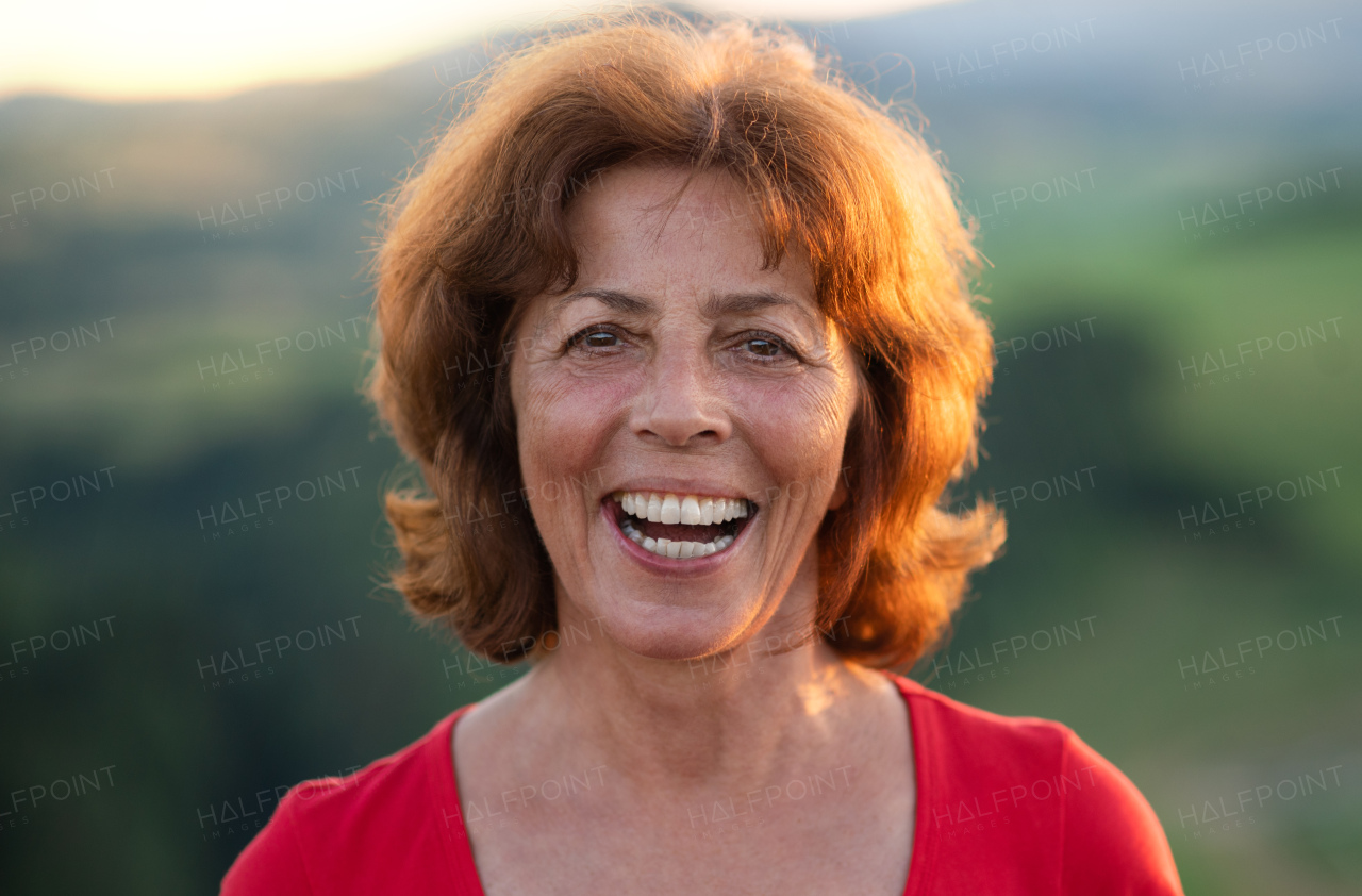 A portrait of senior tourist woman hiker standing in nature. Copy space.