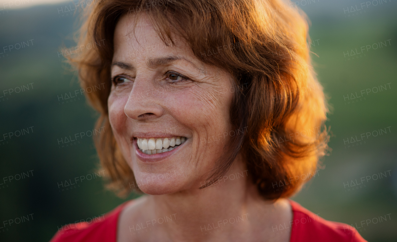 A portrait of senior tourist woman hiker standing in nature.