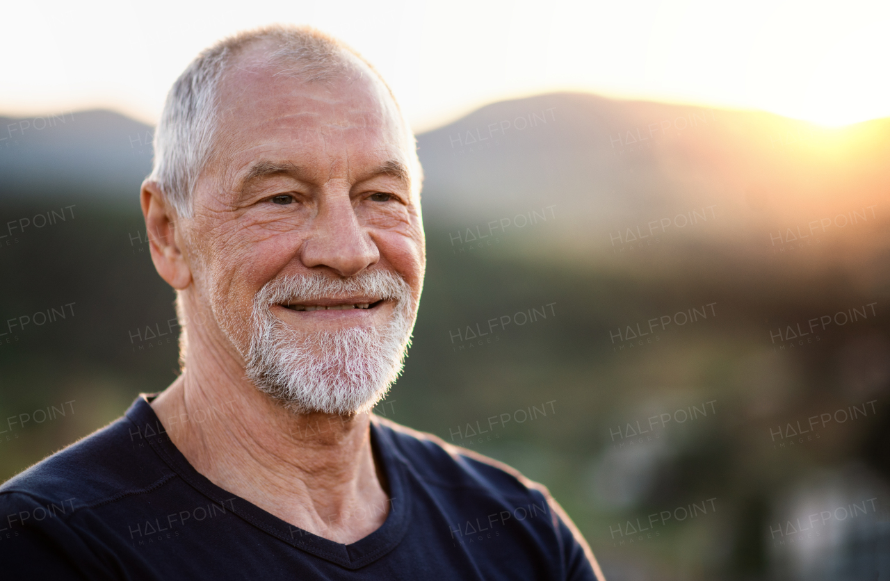 A portrait of senior tourist hiker standing in nature. Copy space.