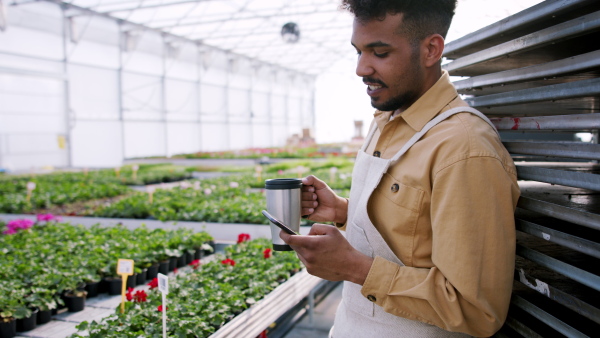 A young worker in garden centre taking a break.