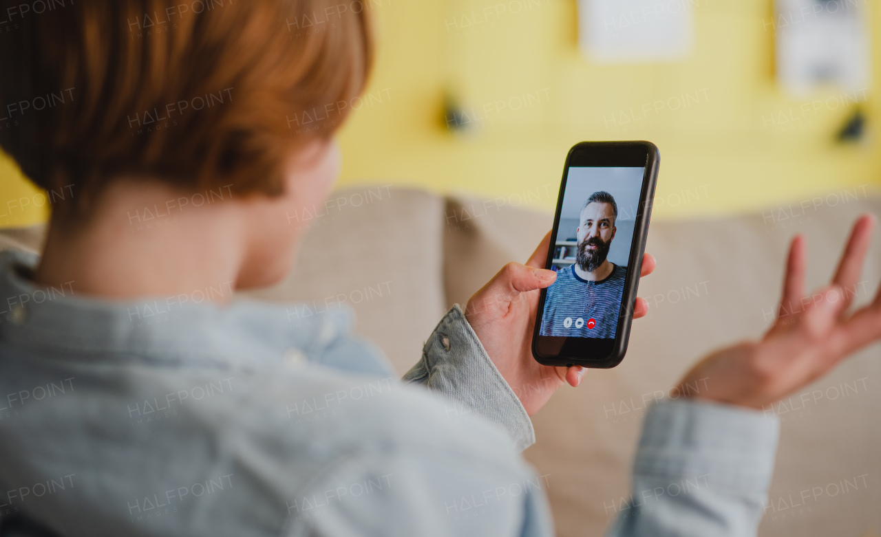 Young woman at home making a video call using smartphone, social networks concept.