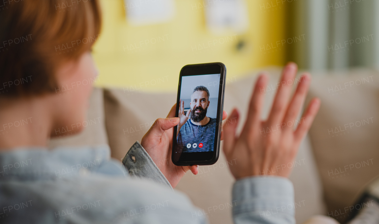 Young woman at home making a video call using smartphone, social networks concept.