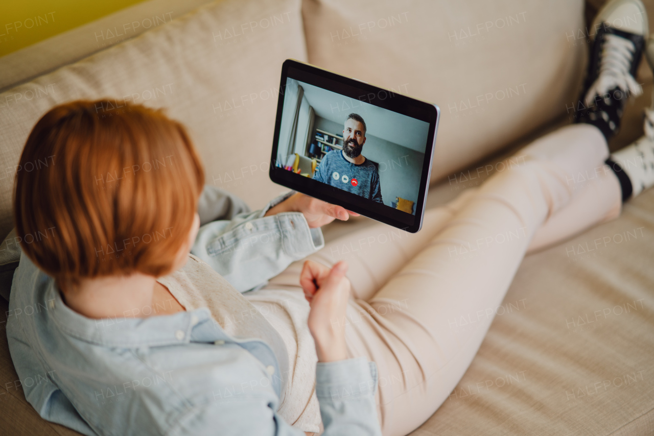 Young woman at home making a video call using tablet, social networks concept.