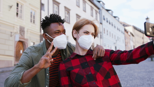 A cheerful teenagers taking selfie on street. Social networks and coronavirus concept.