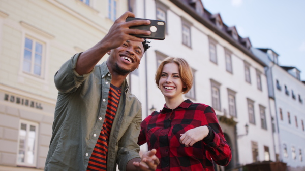 A cheerful teenagers taking selfie on street. Social networks concept.