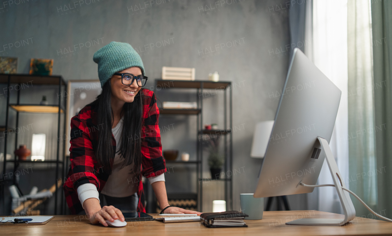 A happy female video editor works indoors in creative office studio.