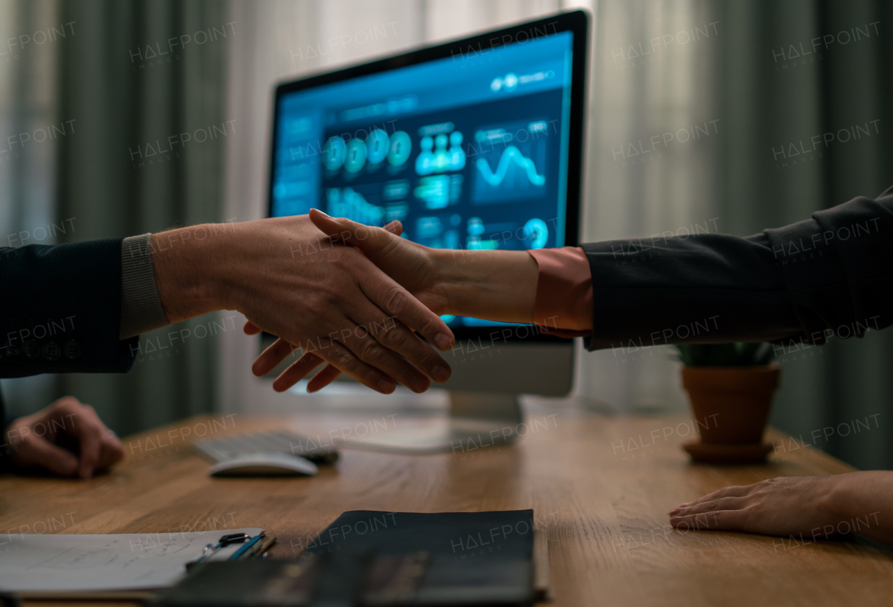 A mature financial advisor shaking hand with his client indoors in office, cut out.