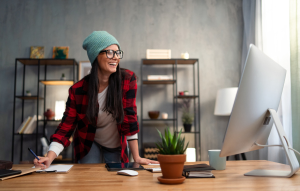 A happy female video editor works indoors in creative office studio