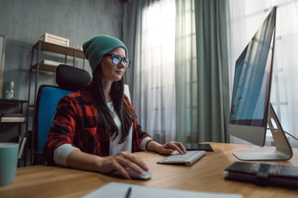 A happy female video editor works indoors in creative office studio