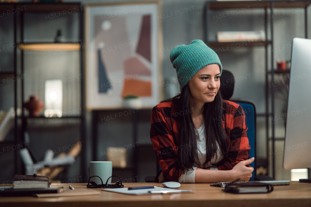 A female video editor works indoors in creative office studio.