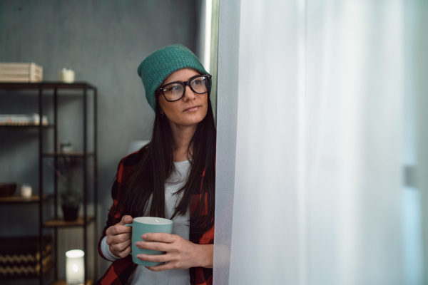 A mid-adult hipster woman having coffee break indoors in creative office studio.