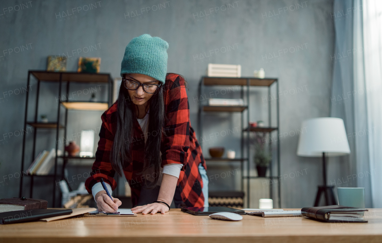 A happy female video editor works indoors in creative office studio.