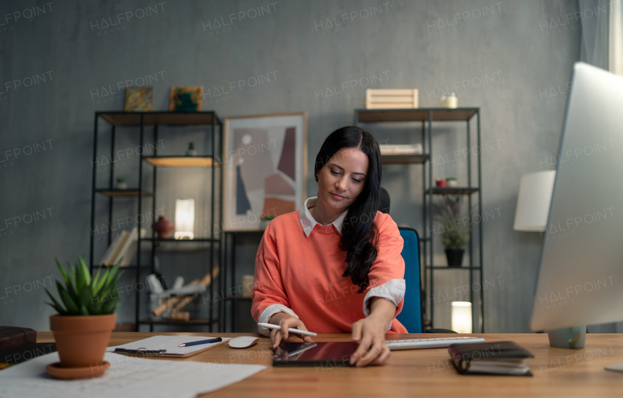 A happy mid adult woman working indoors in office.