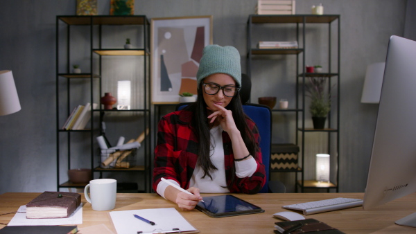 A female video editor working indoors in creative office studio, looking at camera.