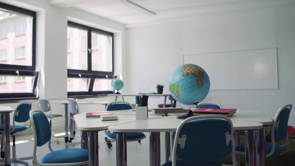 A globe on the desk in unconventional classoom in private school.