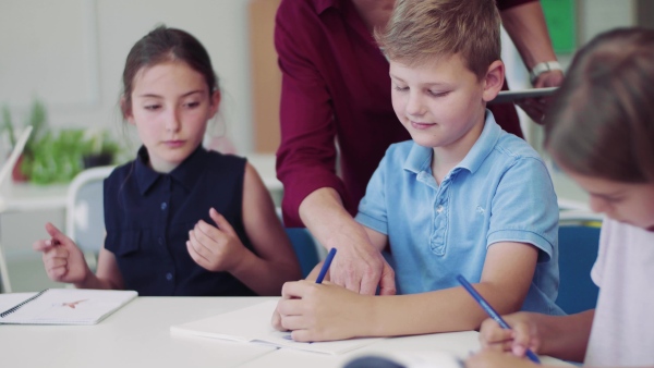 A group of small school kids in class, drawing.