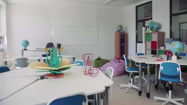 Desks with props in a classroom in private school, unconventional learning. Slow motion.