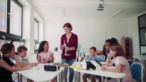 A group of small school kids with teacher in science class learning about environment. Slow motion.