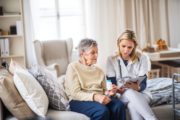 A young health visitor explaining a senior woman how to take medicine and pills.