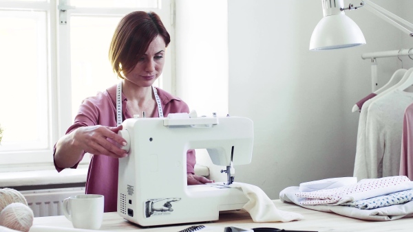 Young creative woman in a studio, working. A startup of small tailoring business.