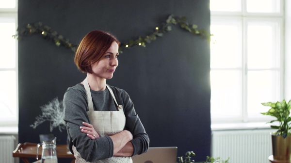 Portrait of young creative woman standing in a flower shop. A startup of florist business.