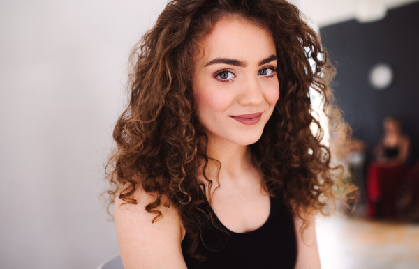 A portrait of beautiful young dance woman teacher indoors looking at camera.