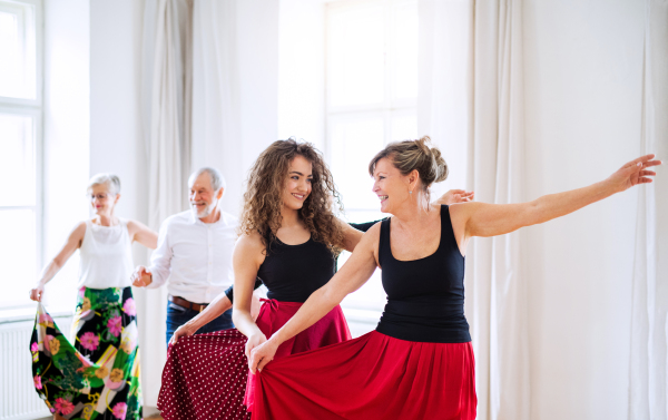 A group of senior people attending dancing class with dance teacher.