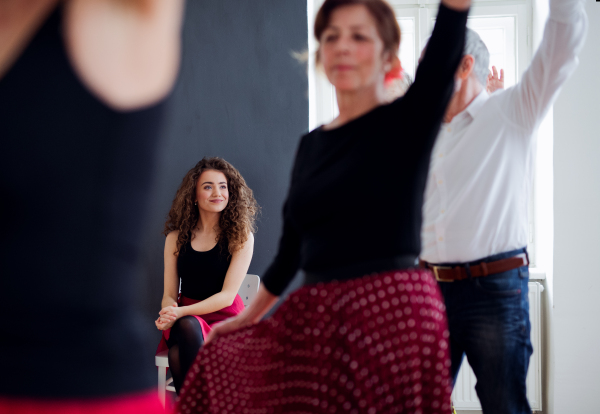 A group of senior people attending dancing class with dance teacher, a midsection.