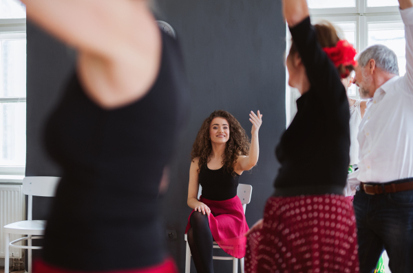 A group of senior people attending dancing class with dance teacher, midsection.