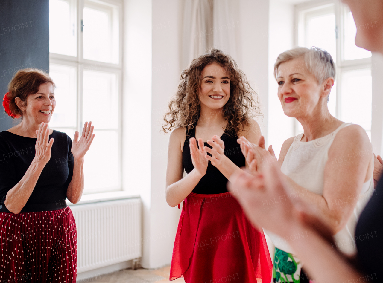 A group of senior women attending dancing class with dance teacher.