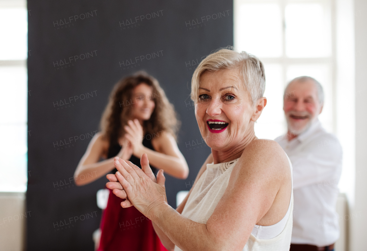 Senior couple attending dancing class with dance teacher.