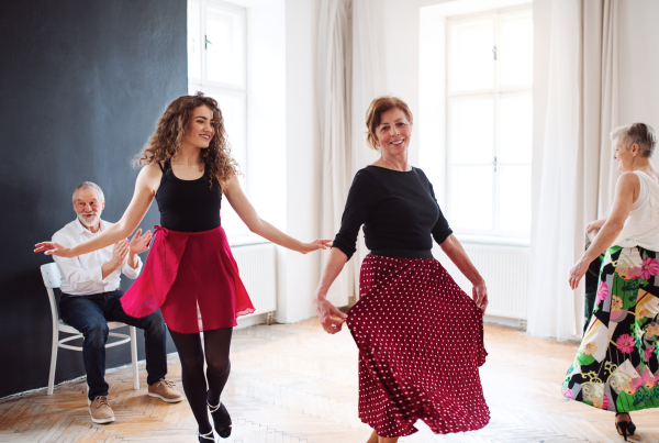 Front view portrait of dance teacher with group of seniors in dancing class.