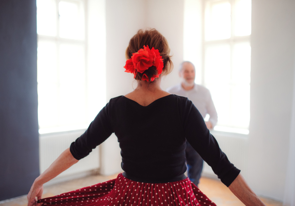 Happy senior couple in love attending dancing class in community center.