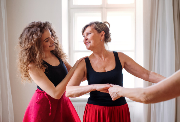 Senior people attending dancing class with dance teacher.