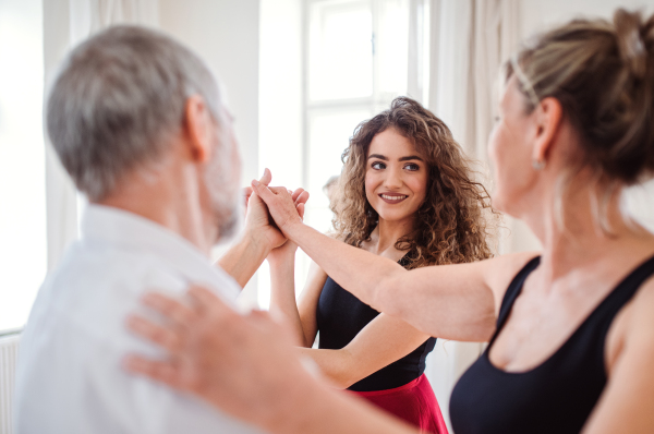 Senior couple attending dancing class with dance teacher.