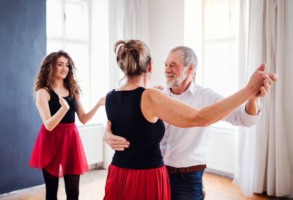 Senior couple attending dancing class with dance teacher.