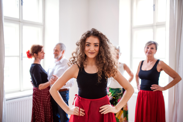 Front view portrait of dance teacher with group of seniors in dancing class.