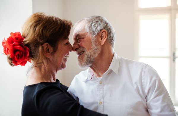 Affectionate senior couple in love attending dancing class in community center.