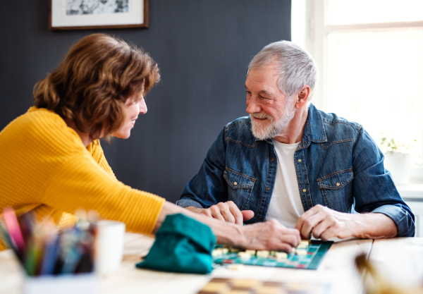 A senior couple playing board games in community center club.