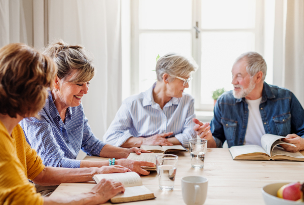 Senior people in bible reading group in community center club, talking.