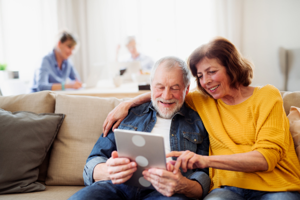 Senior couple using tablet in community center club, technology in everyday life concept.