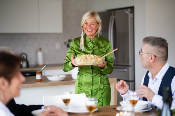 Group of senior friends enjoying dinner party at home.