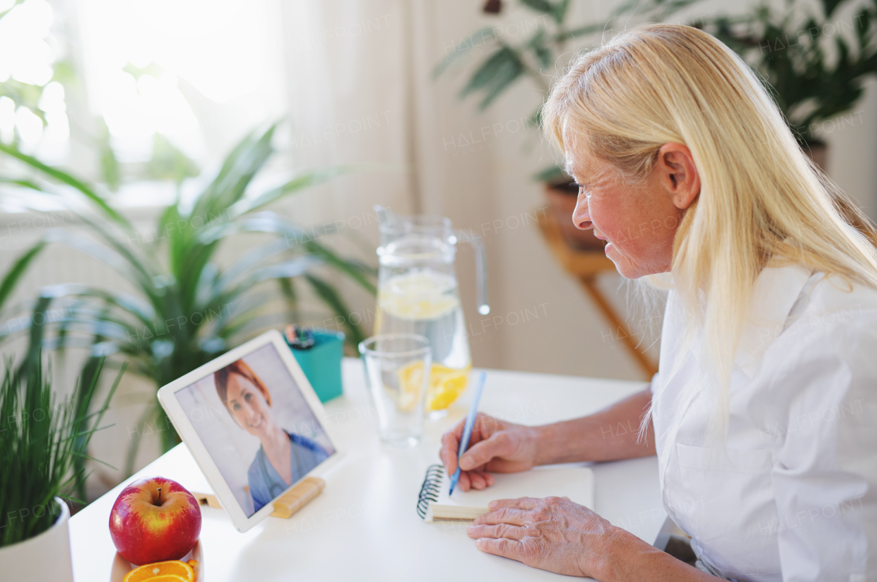 Senior woman with laptop indoors at home , consulting doctor and video call concept.