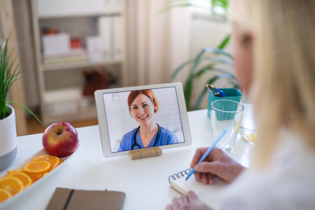 Senior woman with laptop indoors at home , consulting doctor and video call concept.