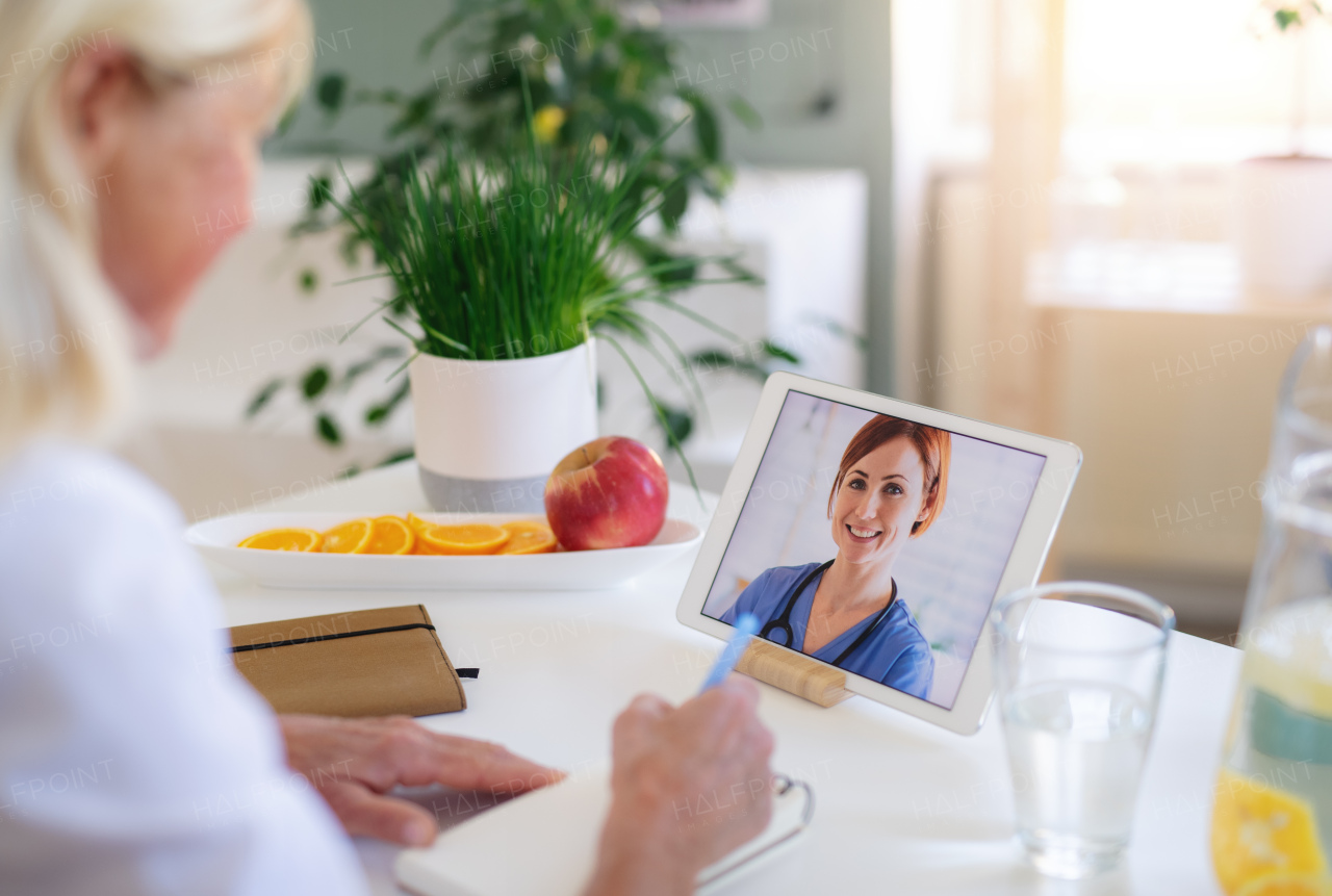 Senior woman with laptop indoors at home , consulting doctor and video call concept.