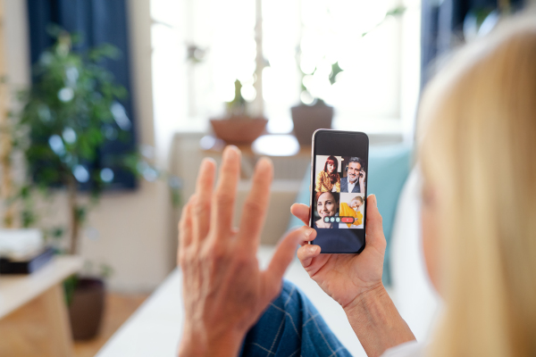 Unrecognizable senior businesswoman with smartphone indoors in home office, business call concept.