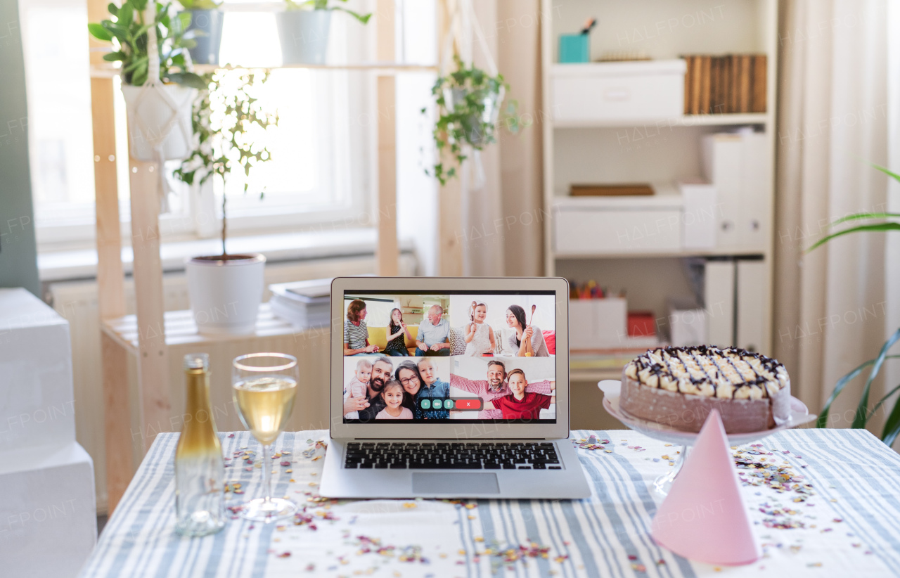 Laptop computer on table indoors, family chat and distance birthday celebration.