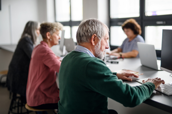 Group of senior people attending computer and technology education class, working.