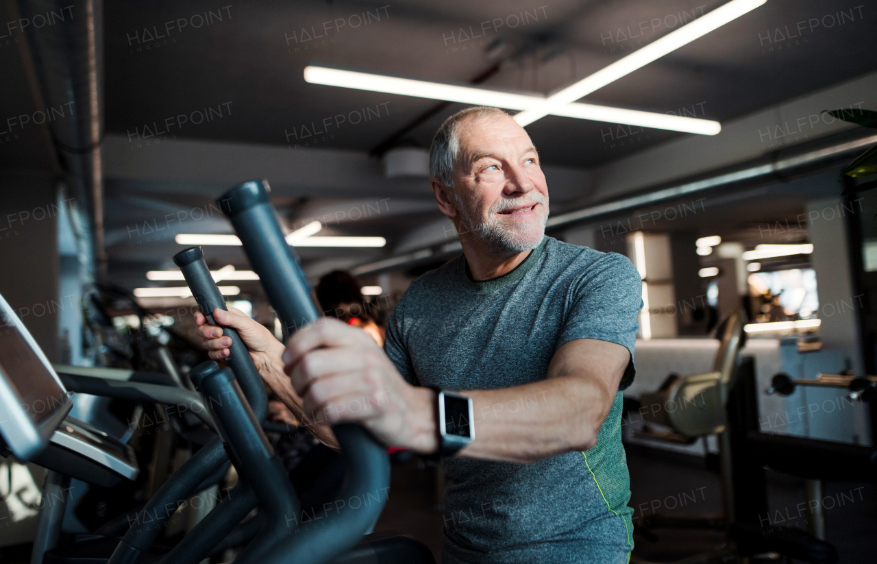 A senior man doing strength workout exercise in gym. A copy space.