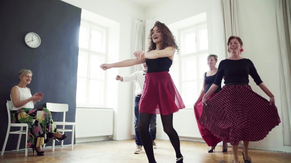 A group of senior people attending dancing class with dance teacher. Slow motion.